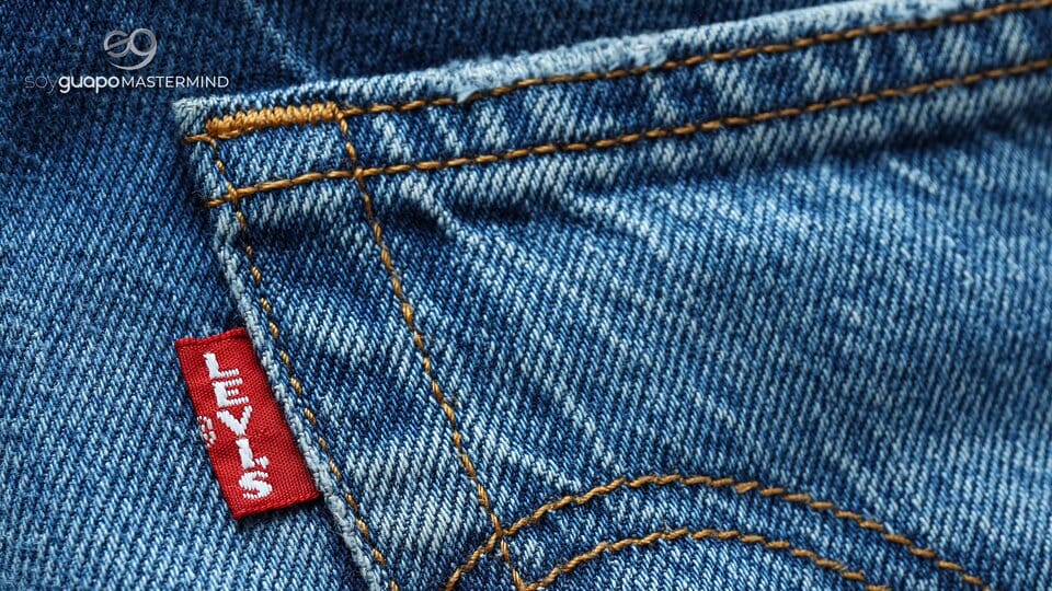 Primer plano de un bolsillo de unos vaqueros Levi's azules con costuras visibles y una etiqueta roja de Levi's en la costura.